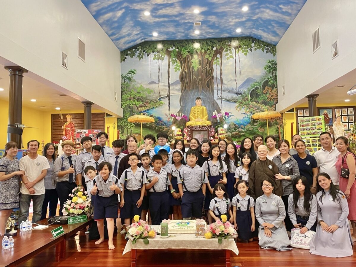 A large group of Vietnamese youth pose in a temple