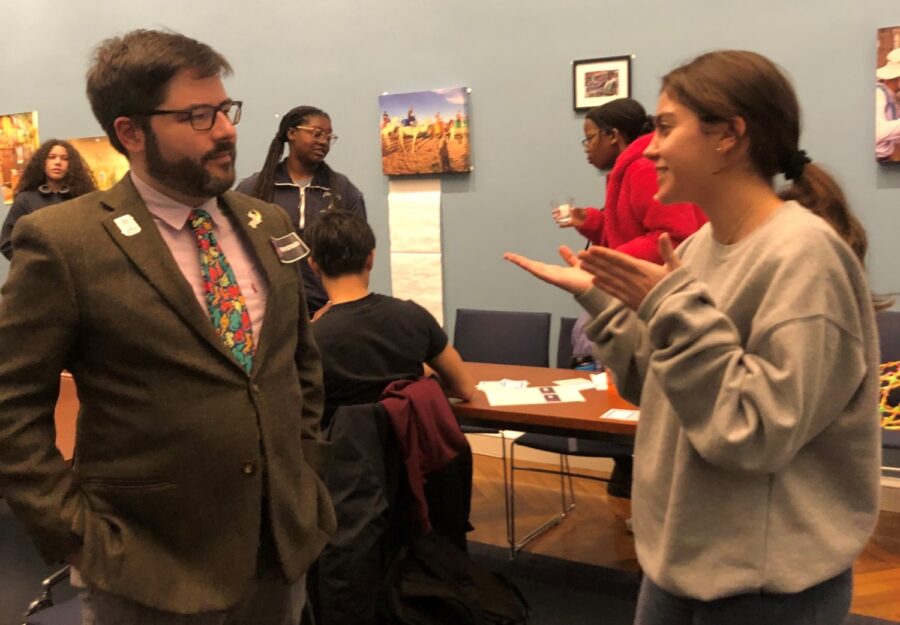 bearded man standing talking to a younger female student