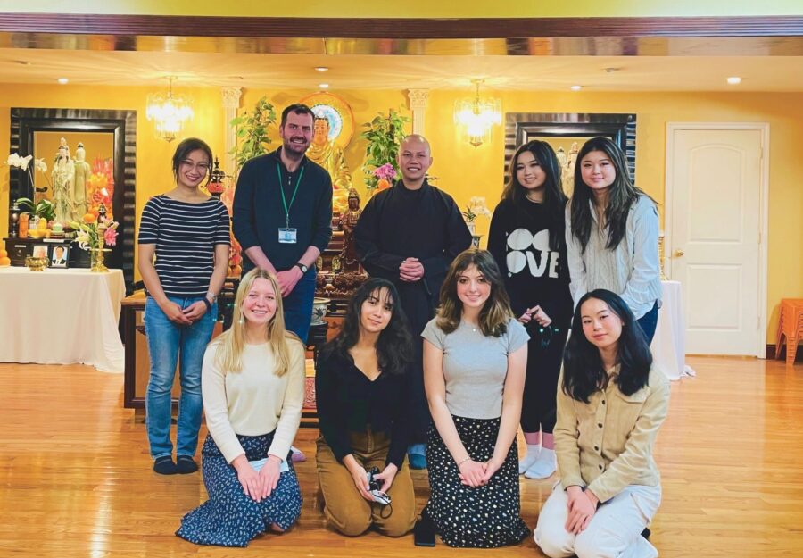 Andy Housiaux and Workshop students at a Buddhist temple standing as a group with a monk