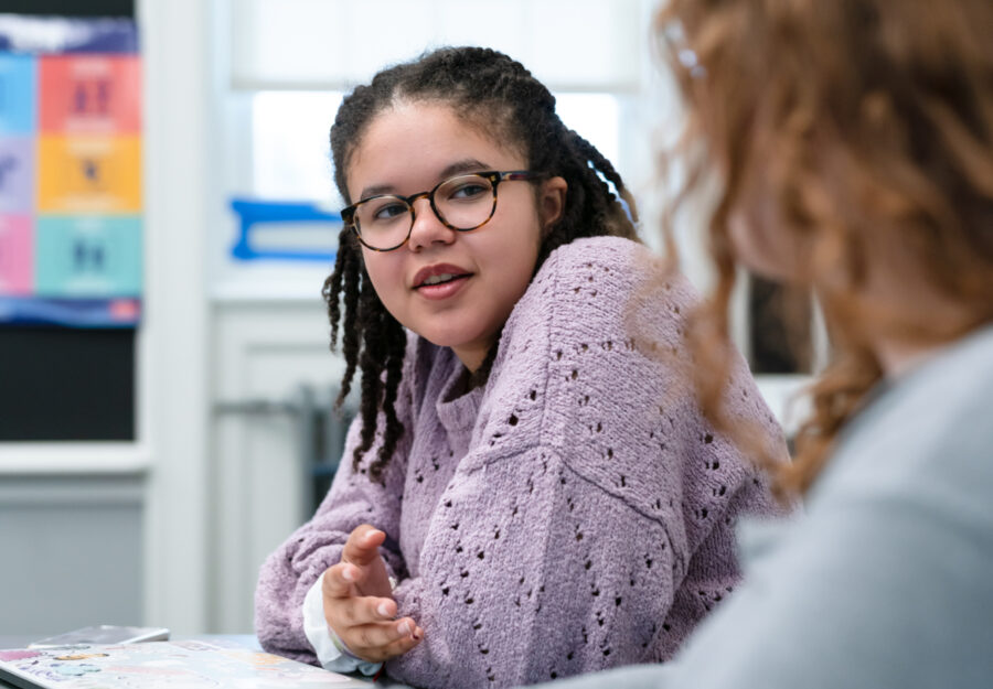 female student at a table engaged in a conversation