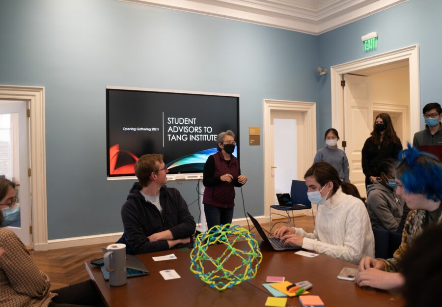 Corrie Martin stands in front of a screen and talks to a group of faculty and students