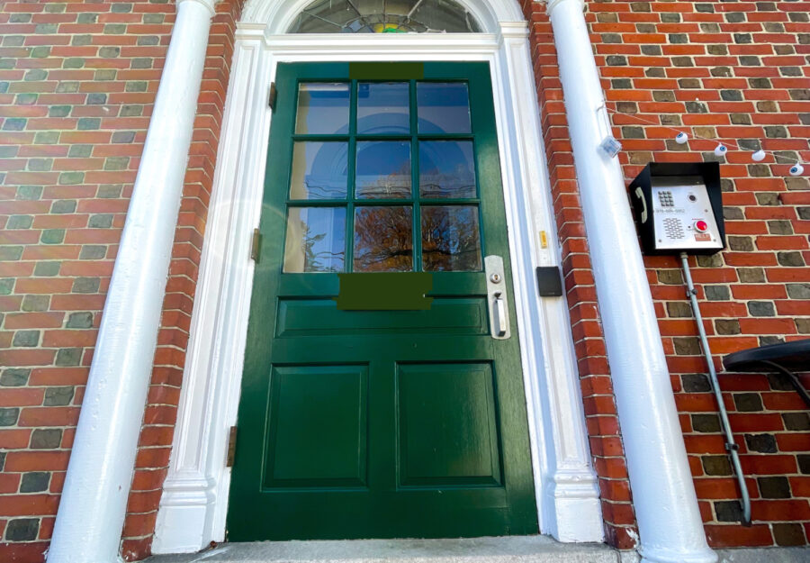 photo of green door of Alumni House & rainbow welcome mat