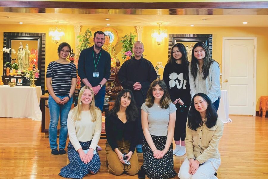 Andy Housiaux and Workshop students at a Buddhist temple standing as a group with a monk