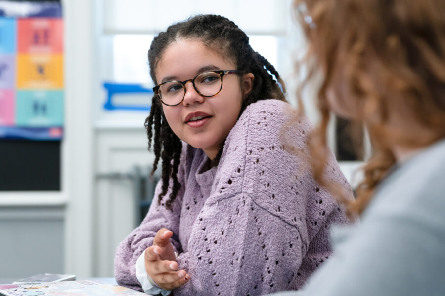female student at a table engaged in a conversation